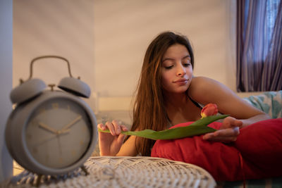 Portrait of young woman sitting on sofa at home