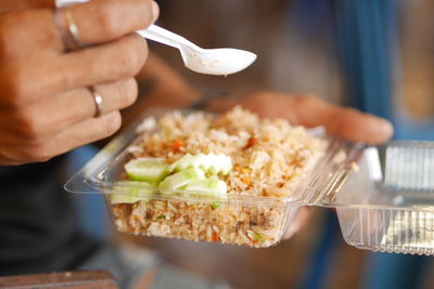 Close-up of person holding food in plastic container