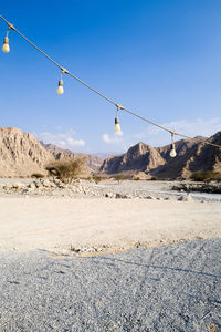 Light bulb string against mountain backdrop