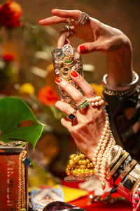 Cropped hands of woman holding champagne flute with jewelry