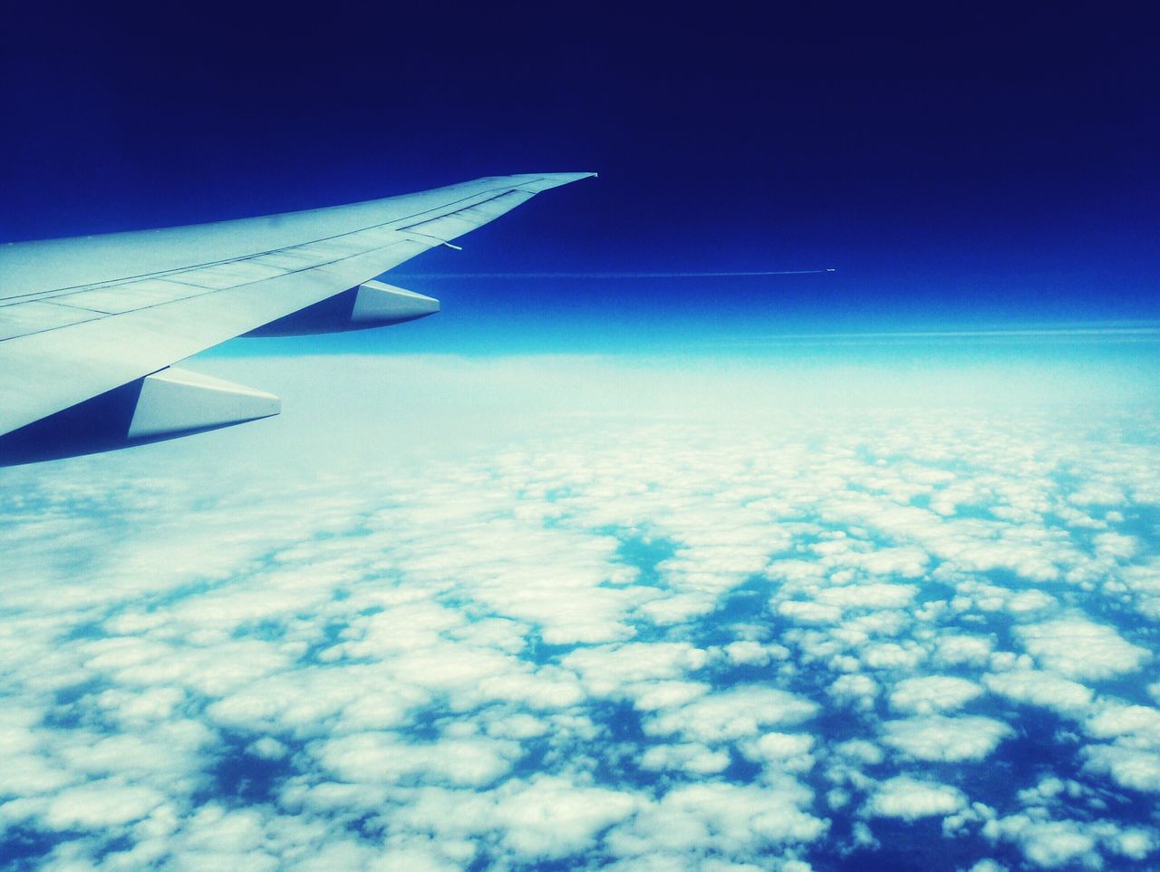 airplane, flying, air vehicle, aircraft wing, blue, aerial view, part of, transportation, mid-air, sky, cropped, mode of transport, journey, travel, cloud - sky, nature, on the move, beauty in nature, scenics, airplane wing