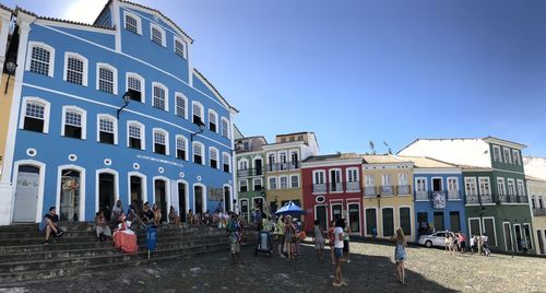 People on street against buildings in city