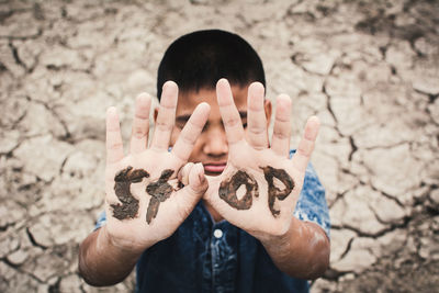 Boy with stop text on hands