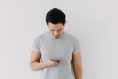 Young woman gesturing against white background