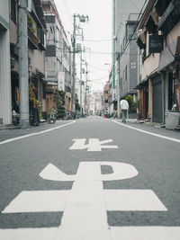 Road sign on street amidst buildings in city