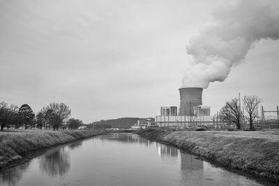 Smoke emitting from factory against sky