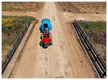 High angle view of man cycling on dirt road