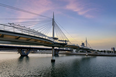 Bridge over river against sky during sunset