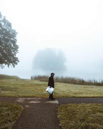 FULL LENGTH OF MAN ON FIELD AGAINST TREES