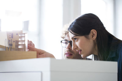 Man and woman discussing architectural model in office