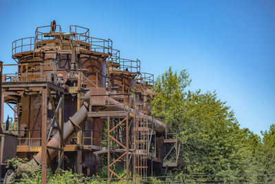 Rusty oil tank against sky