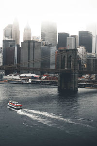 Brooklyn bridge over east river against buildings in city