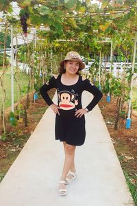 Portrait of smiling young woman standing against trees