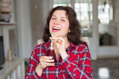 Portrait of smiling woman drinking drink