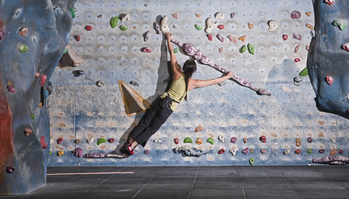 Mature woman practising at indoor climbing wall in the uk