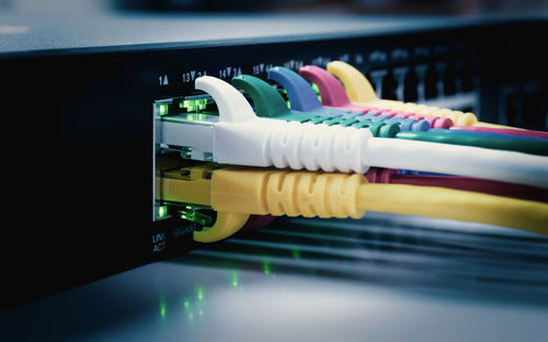 Close-up of cable attached routers on table