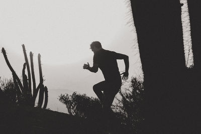 Low angle view of silhouette man standing against sky during sunset