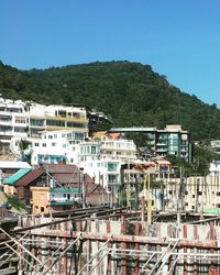 Buildings in city against clear blue sky