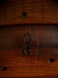 Close-up of old wooden table against wall