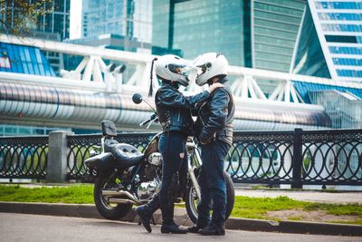 Motorcyclists embracing in city