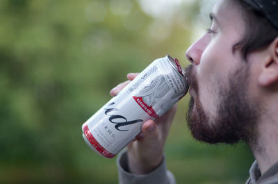 Side view portrait of a young man drinking water