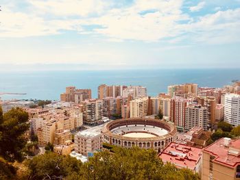 High angle view of buildings and sea against sky