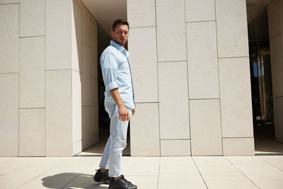 Low section of man standing against wall