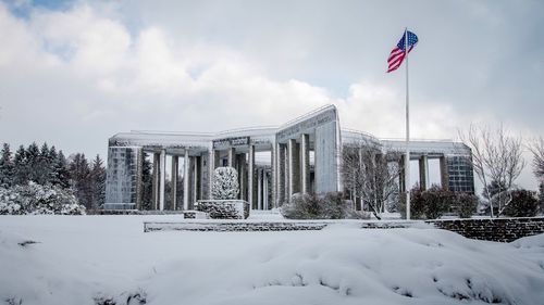 Flags on snow covered landscape against sky