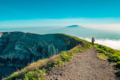 Scenic view of a hiker at volcanic crater - the ash pit on mount ol doinyo lengai in tanzania