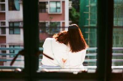 Rear view of women seen from window