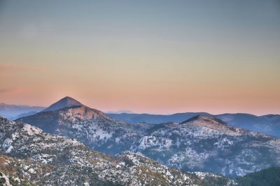 Scenic view of snowcapped mountains against sky during sunset