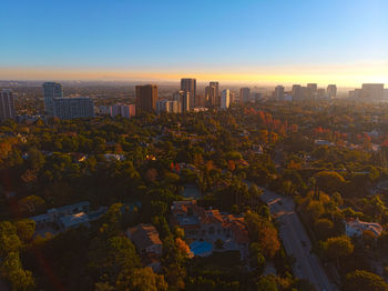 Aerial view of buildings in city against sky during sunset