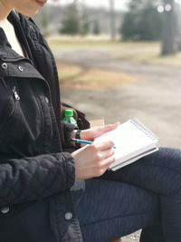 Midsection of man holding book