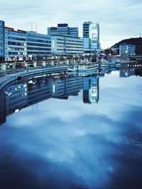 Reflection of buildings in lake against sky