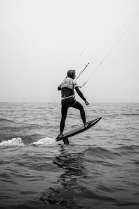 Rear view of man in sea against sky