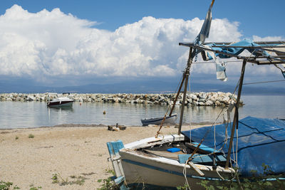 Sailboats moored on sea against sky