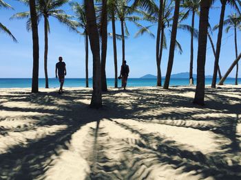 People standing on beach against sky