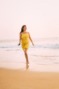 Full length of boy on beach against sky