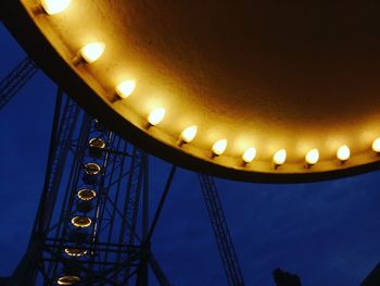 Low angle view of illuminated lamp against blue sky