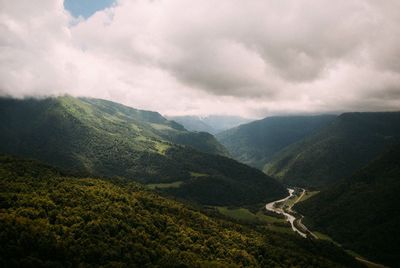Scenic view of mountains against cloudy sky