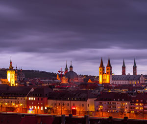 Illuminated buildings in city against sky at night