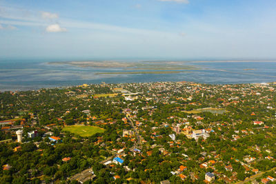 High angle view of townscape by sea against sky
