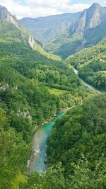 High angle view of river amidst mountains against sky