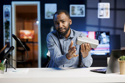 Young man using mobile phone while sitting on table