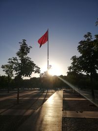 Red flag on road against sky during sunset