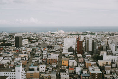 High angle view of townscape by sea against sky