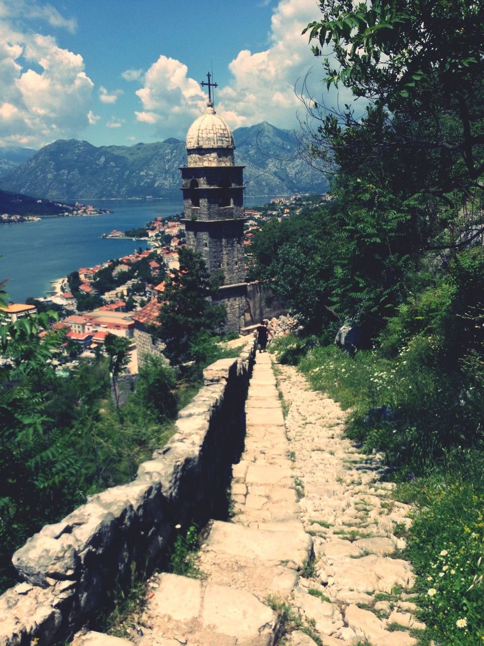 sky, the way forward, built structure, architecture, water, building exterior, leading, cloud - sky, cloud, tranquility, tree, mountain, footpath, tranquil scene, sea, nature, walkway, diminishing perspective, day, narrow