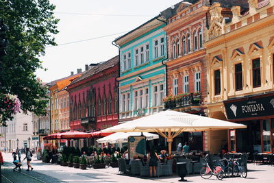 People on street amidst buildings in city