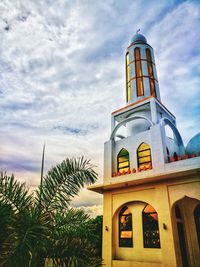 Low angle view of palm trees and building against sky