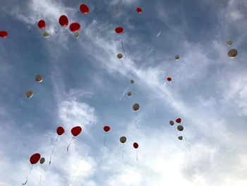 Low angle view of balloons flying against sky